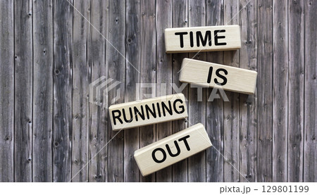 Wooden blocks with the inscription TIME IS SUNCTING OUT on a wooden background 129801199