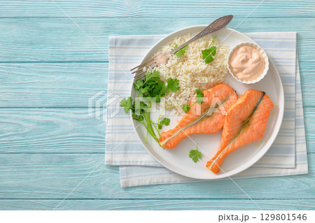 baked salmon steaks with rice, cilantro and sauce baked salmon steaks with rice, cilantro and sauce 129801546