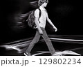 Student walking fast at night with motion blur effect 129802234