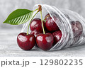Fresh red cherries spilling from plastic bag on gray surface. Preparing for winter storage 129802235