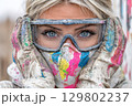 Painter woman wearing protective glasses and mask covered in paint 129802237