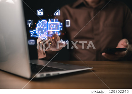 A businessman use futuristic AI power digital interface display artificial intelligence, machine learning, data analytics, automation, and media technology, symbol innovation and smart solutions. A businessman use futuristic AI power digital interface display artificial intelligence, machine learning, data analytics, automation, and media technology, symbol innovation and smart solutions. 129802246