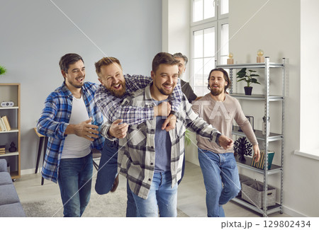 Group of happy joyful excited men hugging and congratulating friend on great success Group of happy joyful excited men hugging and congratulating friend on great success 129802434