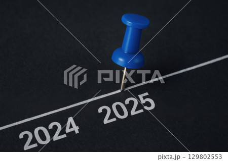 Blue pushpin marking year 2025 on black textured timeline, symbolizing future planning and business forecast with clear focus and sharp detail Blue pushpin marking year 2025 on black textured timeline, symbolizing future planning and business forecast with clear focus and sharp detail 129802553