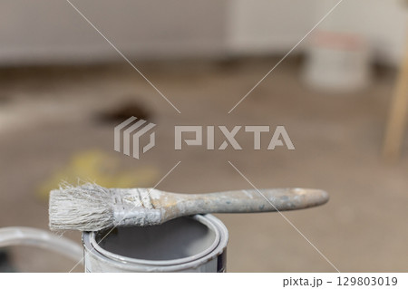 A Paint Brush is Resting Carefully on a Can Inside a Renovation Setting and Environment A Paint Brush is Resting Carefully on a Can Inside a Renovation Setting and Environment 129803019