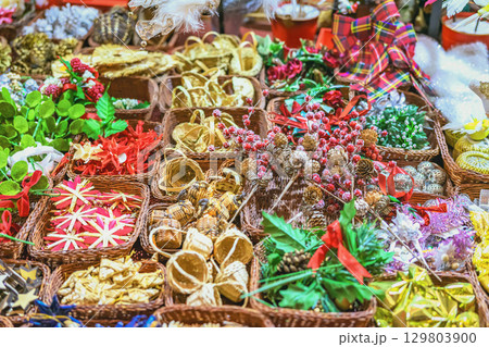 Handmade Christmas decorations closeup, top view. Assorted handmade Christmas decorations arranged in wicker baskets at festive market. Concept of holiday craft decor, colorful seasonal tradition Handmade Christmas decorations closeup, top view. Assorted handmade Christmas decorations arranged in wicker baskets at festive market. Concept of holiday craft decor, colorful seasonal tradition 129803900