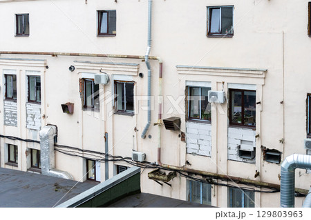 Air conditioners are installed on facade of building. device for comfortable living in hot weather. 129803963