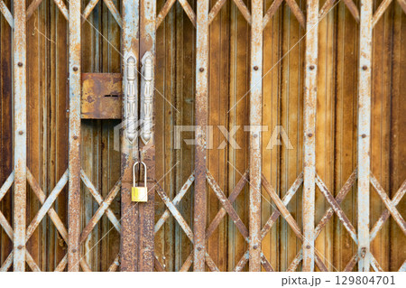 Vintage and rusty expandable steel gate with classic folding design Vintage and rusty expandable steel gate with classic folding design 129804701