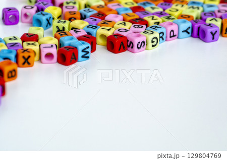 A zoomed in arrangement of bright multicolored cubes with letters scattered randomly symbolizing creativity, word building, and educational playfulness 129804769
