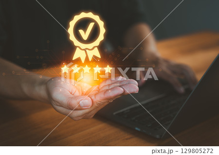 Person holding and showing the best quality assurance with golden five stars, representing high quality service, customer satisfaction, digital excellence, guarantee, standard, and testimonial. 129805272