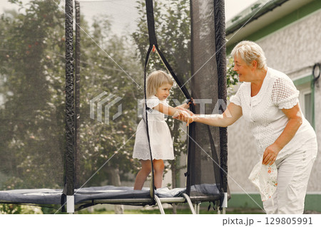Family in a back yeard. Granddaughter with grandmother. 129805991
