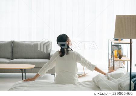 朝起きてストレッチをする女性の後ろ姿 朝起きてストレッチをする女性の後ろ姿 129806460