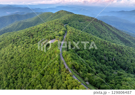 Winding road at Mount Mitchell Overlook on Blue Ridge Parkway in North Carolina Appalachian mountains. Forest with green canopies in summertime. Driving through wild woods nature in summer 129806487