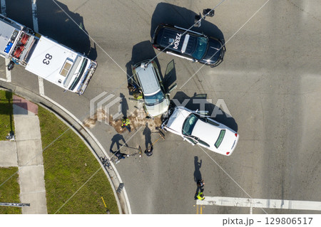 Traffic accident on American street in Florida. First responders helping victims of car crash on road in USA. Aerial view of emergency services responding to accident site Traffic accident on American street in Florida. First responders helping victims of car crash on road in USA. Aerial view of emergency services responding to accident site 129806517