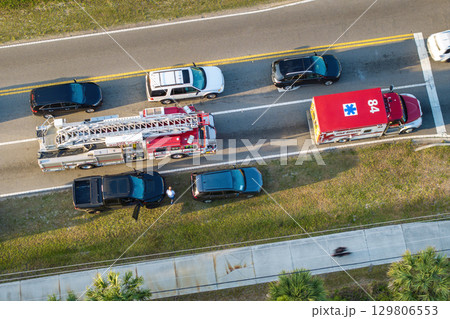 Car accident on American street. Emergency services helping victims of vehicle crash on road in USA 129806553