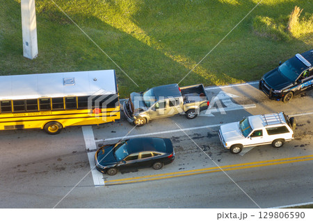 Car accident on city street in Florida. School bus and truck collision. Result of distracted driving and speeding. Emergency services at vehicle crash in USA 129806590
