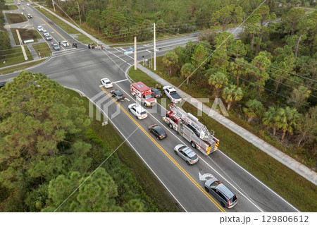 Traffic accident on American street in Florida. First responders helping victims of car crash on road in USA. Aerial view of emergency services responding to accident site Traffic accident on American street in Florida. First responders helping victims of car crash on road in USA. Aerial view of emergency services responding to accident site 129806612