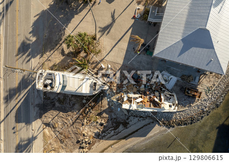 Destroyed sailing yacht capsized on shallow bay waters after hurricane Milton on Manasota Key in Englewood, Florida 129806615