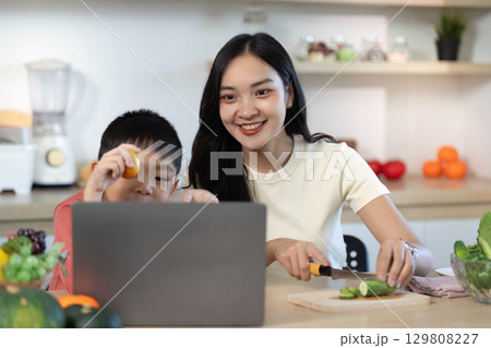 Joyful Cooking: Mother and Son Engaged in Healthy Meal Preparation 129808227