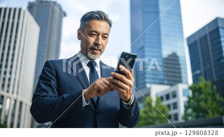 《AI画像》スマホで株取引をするビジネスマン 129808328