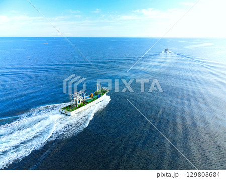 夏の北海道森町で森漁港を出漁する漁船の風景を空撮 129808684