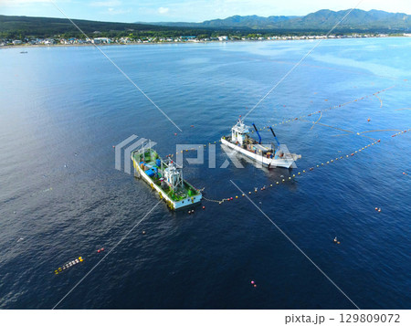 夏の北海道森町沖の噴火湾(内浦湾)で定置網漁の漁船の風景を空撮 夏の北海道森町沖の噴火湾(内浦湾)で定置網漁の漁船の風景を空撮 129809072