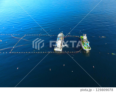 夏の北海道森町沖の噴火湾(内浦湾)で定置網漁の漁船の風景を空撮 夏の北海道森町沖の噴火湾(内浦湾)で定置網漁の漁船の風景を空撮 129809078
