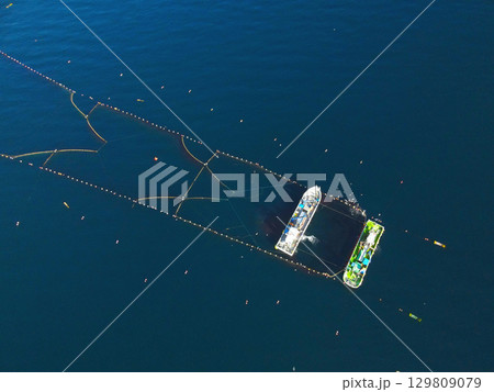 夏の北海道森町沖の噴火湾（内浦湾）で定置網漁の漁船の風景を空撮 129809079