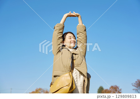 女性　ミドルエイジ　伸び　青空 129809813