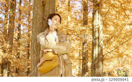 紅葉の中でスマホで電話する女性 ミドルエイジ 紅葉の中でスマホで電話する女性 ミドルエイジ 129809841