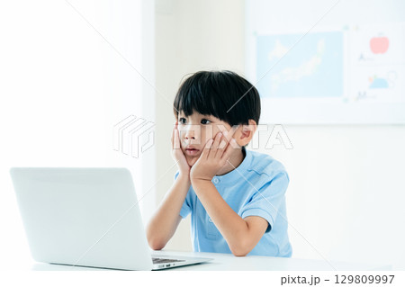 パソコンの前で授業を受ける男の子 129809997