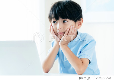パソコンの前で授業を受ける男の子 129809998