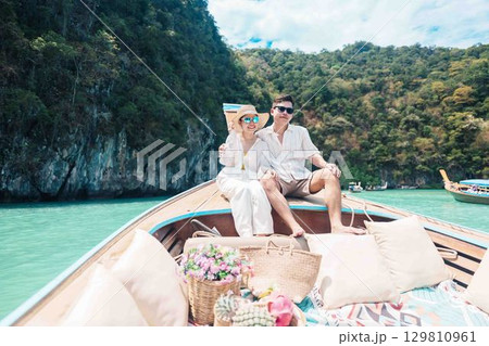 Happy couple tourist in private longtail boat trip to koh Hong lagoon island at Krabi, Thailand. Honeymoon, tropical destination, southeast Asia Travel, summer vacation and wanderlust concept 129810961