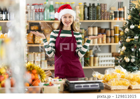 Portrait of positive female seller behind grocery store counter 129811015