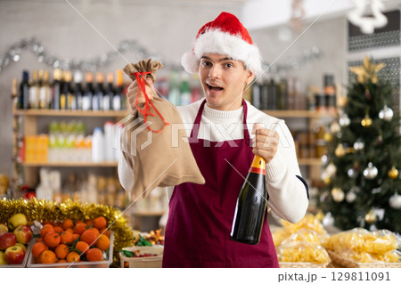 On New Years Eve, sales guy works in store, prepares to celebrate holiday at workplace On New Years Eve, sales guy works in store, prepares to celebrate holiday at workplace 129811091