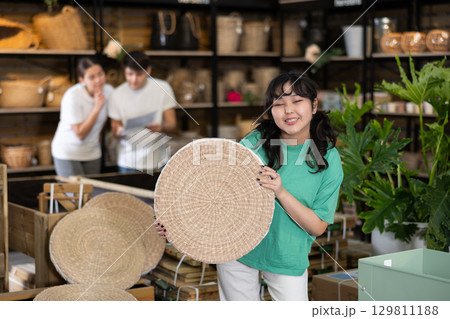 Young asian girl choosing wicker seat at home decor store 129811188