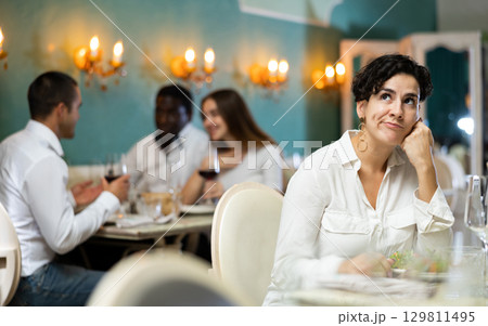 Sad woman with glass at the restaurant 129811495