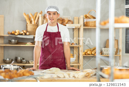 Young guy standing in bakehouse, ready to start baking 129811543