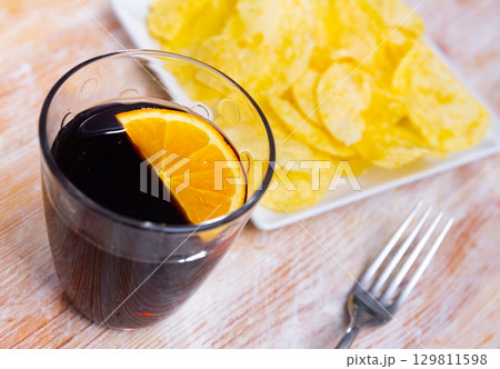 Glass of vermouth served with chips for snack Glass of vermouth served with chips for snack 129811598
