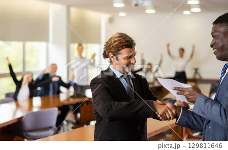 Businessmen handshaking after having agreement Businessmen handshaking after having agreement 129811646