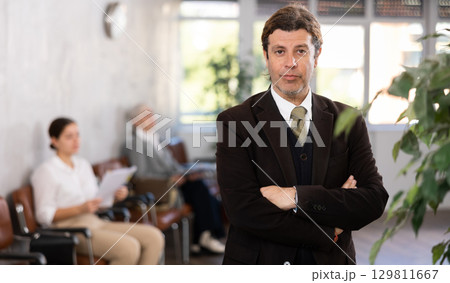 Adult man in business suit posing in office Adult man in business suit posing in office 129811667