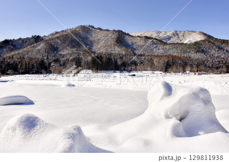 雪に覆われた畑の向こうに山が見える景色が綺麗 雪に覆われた畑の向こうに山が見える景色が綺麗 129811938