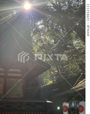 神社の屋根に降り注ぐ光 129812111