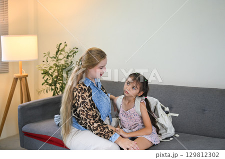 Concerned mother comforting her daughter who looks reluctant to go to school 129812302