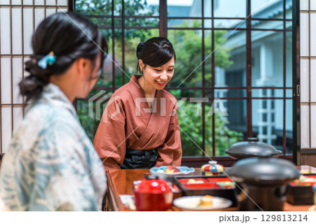 旅館,割烹日本料理店で食事を配膳する旅館スタッフの女性,仲居,女将 129813214