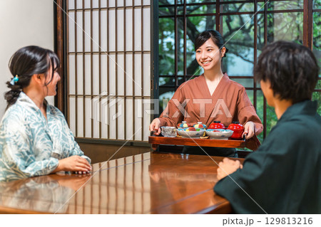 旅館,割烹日本料理店で食事を配膳する旅館スタッフの女性,仲居,女将 129813216