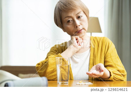 多量の薬を飲むシニア女性 多量の薬を飲むシニア女性 129814621