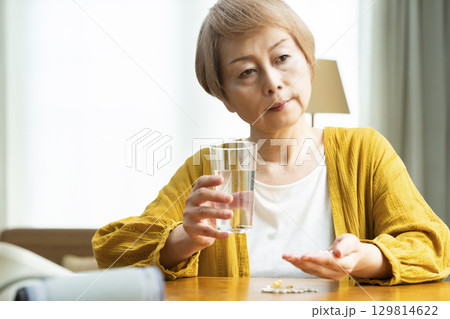多量の薬を飲むシニア女性 129814622