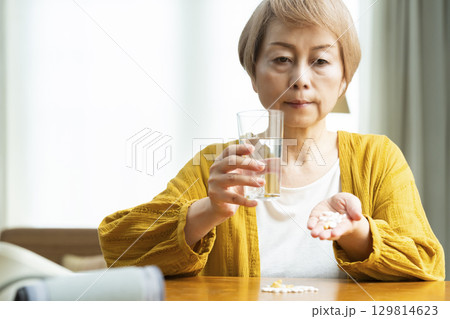 多量の薬を飲むシニア女性 129814623