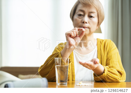 多量の薬を飲むシニア女性 129814627